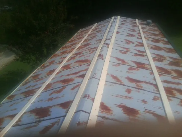 Rusted metal roof panels with new wood purlins before replacement — Storm Damage Roof Repair in Greensboro by Roofing Brothers